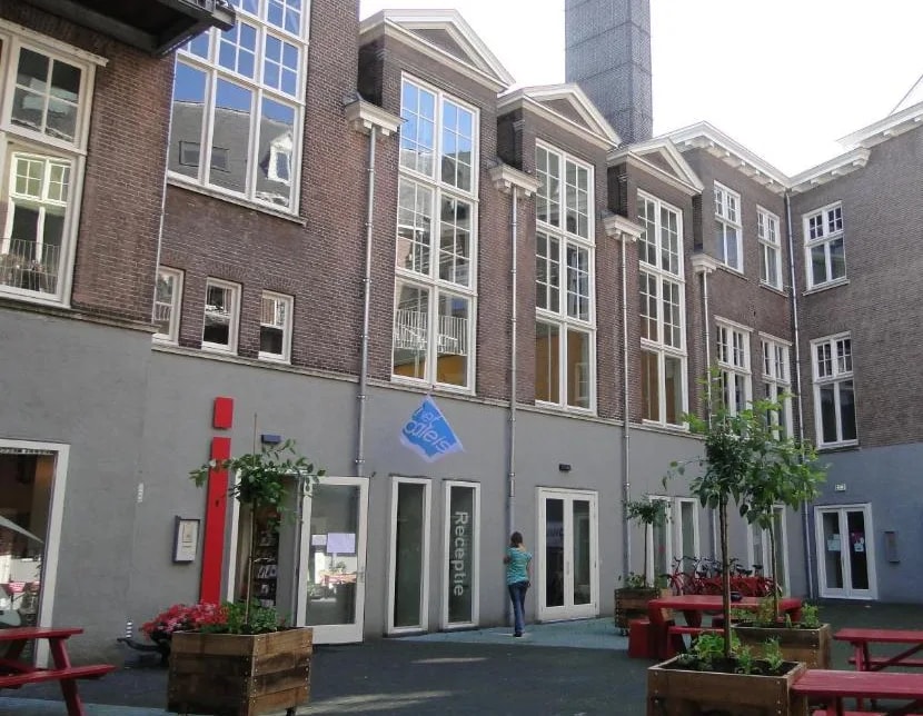 The inner courtyard of a converted brick building, with picnic benches